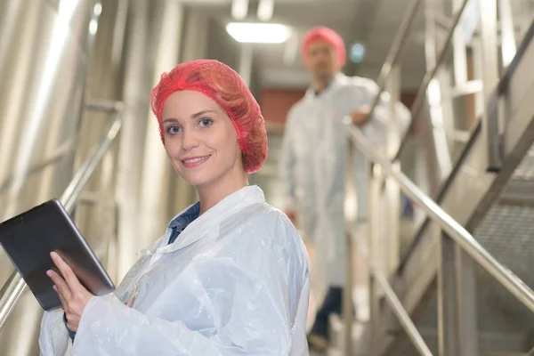 Arbeiterin in einer Lebensmittelfabrik mit Schutzmütze und Mantel — Stockfoto