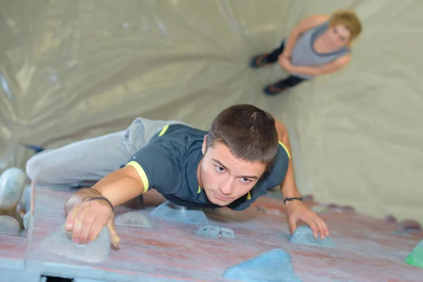 Homem na parede de escalada interior — Fotografia de Stock