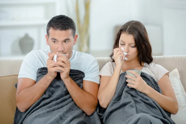 Krankes Paar sitzt zu Hause und trinkt Tee — Stockfoto