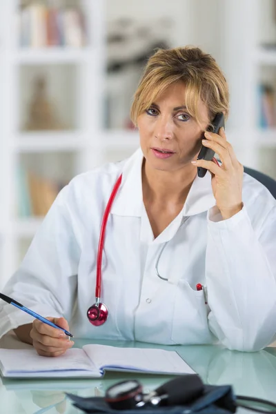 Vrouwelijke arts in gesprek over de telefoon in diagnostisch centrum — Stockfoto