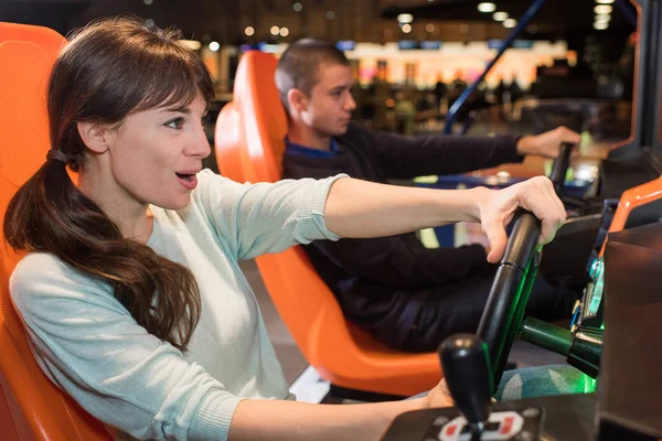 Ett ungt par i casual kläder spelar racingspel — Stockfoto