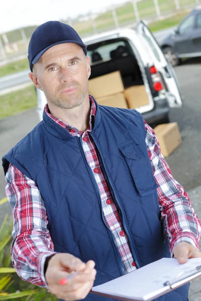 A handsome young delivery man delivering a package — Stock Photo, Image