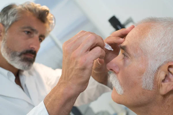 Zdravotní sestra uvedení oční kapky do očí pacientů — Stock fotografie