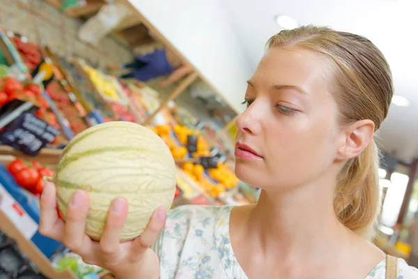 Vrouw selecteren een meloen — Stockfoto