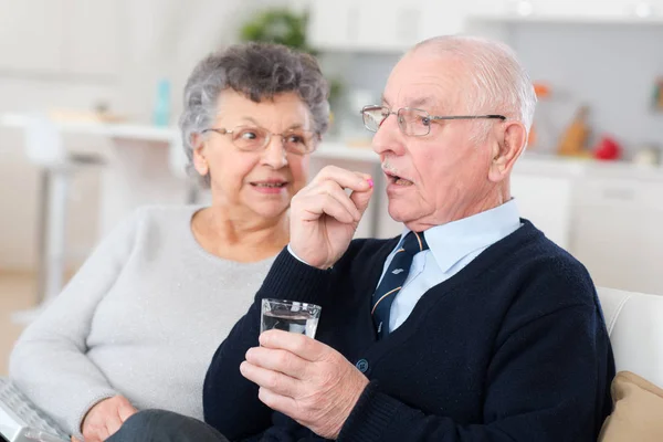 Senior man nemen geneesmiddel met vrouw — Stockfoto