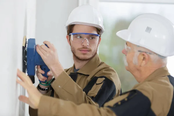 Dois construtores lixando uma parede — Fotografia de Stock