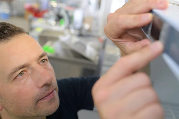 Tecnico uomo che ripara una stampante sul posto di lavoro — Foto Stock