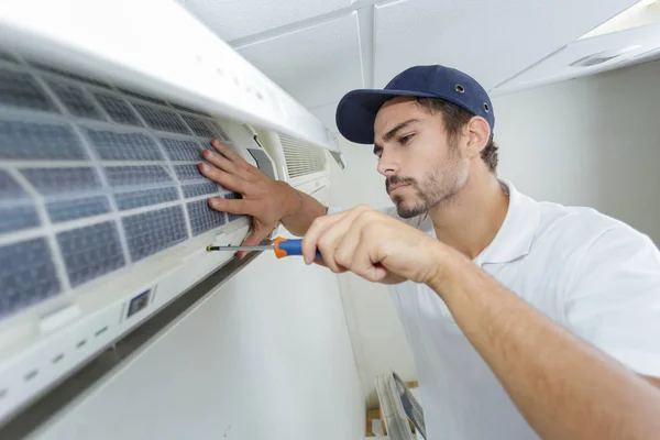 Porträt eines erwachsenen Technikers, der eine Klimaanlage repariert — Stockfoto