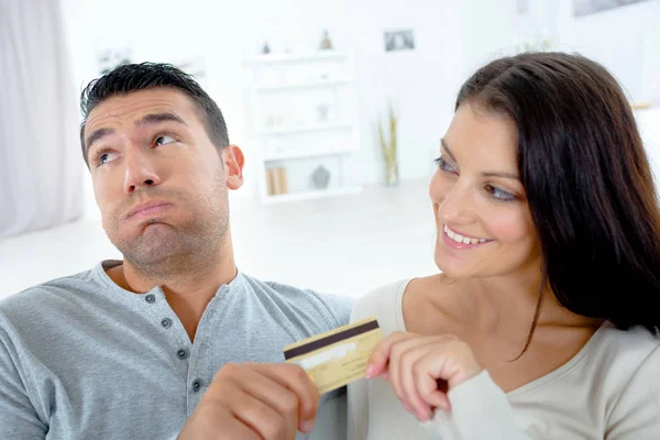 Happy woman and frustrated boyfriend giving cedit card to her — Stock Photo, Image
