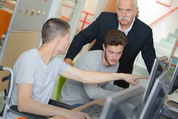 Jongen in rolstoel in de klas — Stockfoto