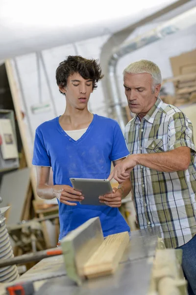 Dos carpinteros mirando la pantalla de la tableta —  Fotos de Stock