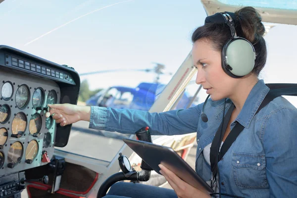 Pilotsitting atrakcyjna kobieta w mały helikopter — Zdjęcie stockowe