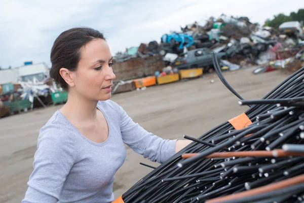 Kobieta w scrapyard układania kabli — Zdjęcie stockowe