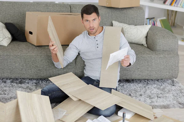 Homem que tem um problema com a montagem de móveis — Fotografia de Stock