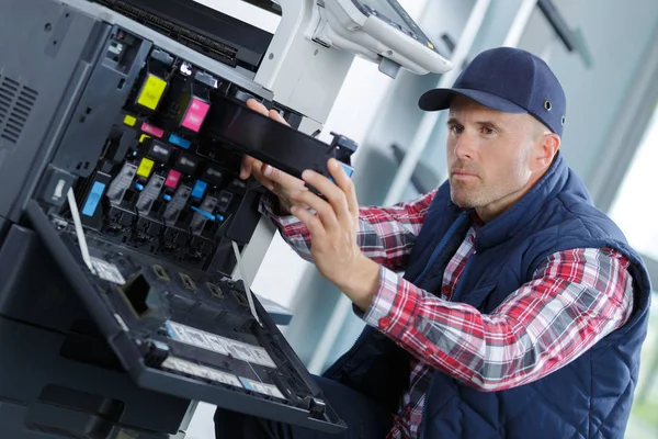 Techniker mit einem Schraubenzieher zur Befestigung des Druckers — Stockfoto