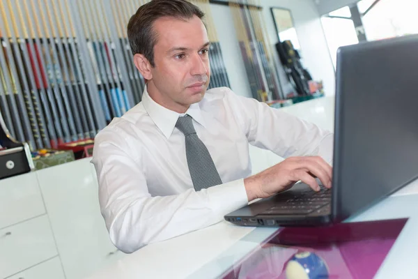 Бизнесмен за ноутбуком в офисе — стоковое фото