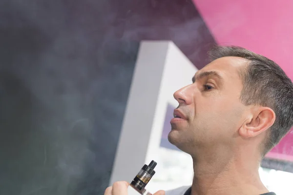 Az ember vaping egy elektronikus cigaretta a vape Shop — Stock Fotó