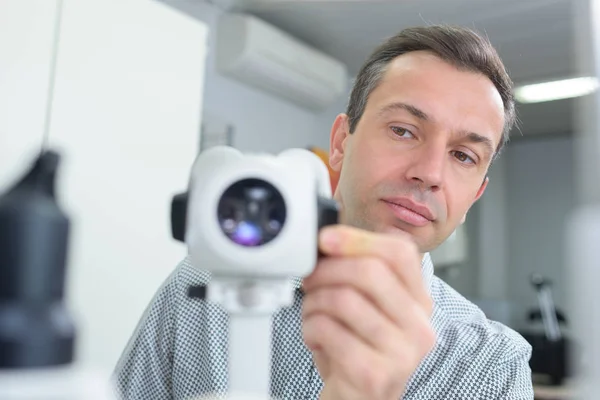 Senior male optician with optical tool — Stock Photo, Image