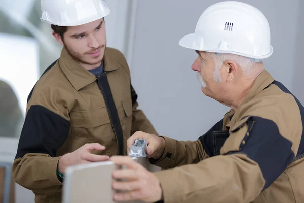 Senior förman är att dela sina idéer med unga byggare — Stockfoto