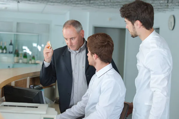 Drie mannen achter de receptie — Stockfoto