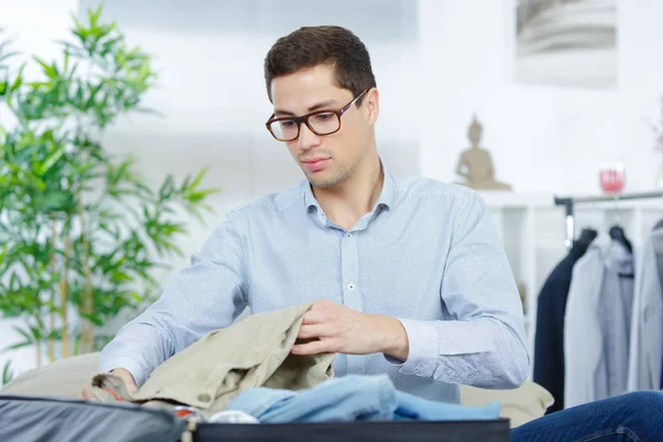 Zakenman reizen verpakking een koffer — Stockfoto