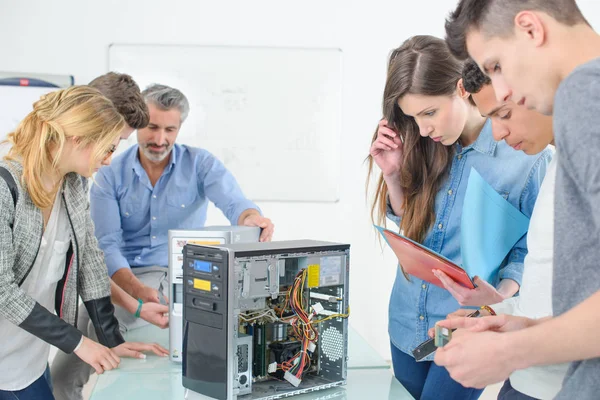 Tutor and student fixing computer in class — Stock Photo, Image