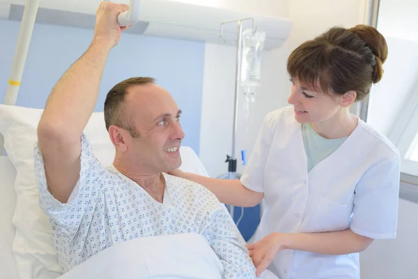 Physician with her patient recovering in bed — Stock Photo, Image