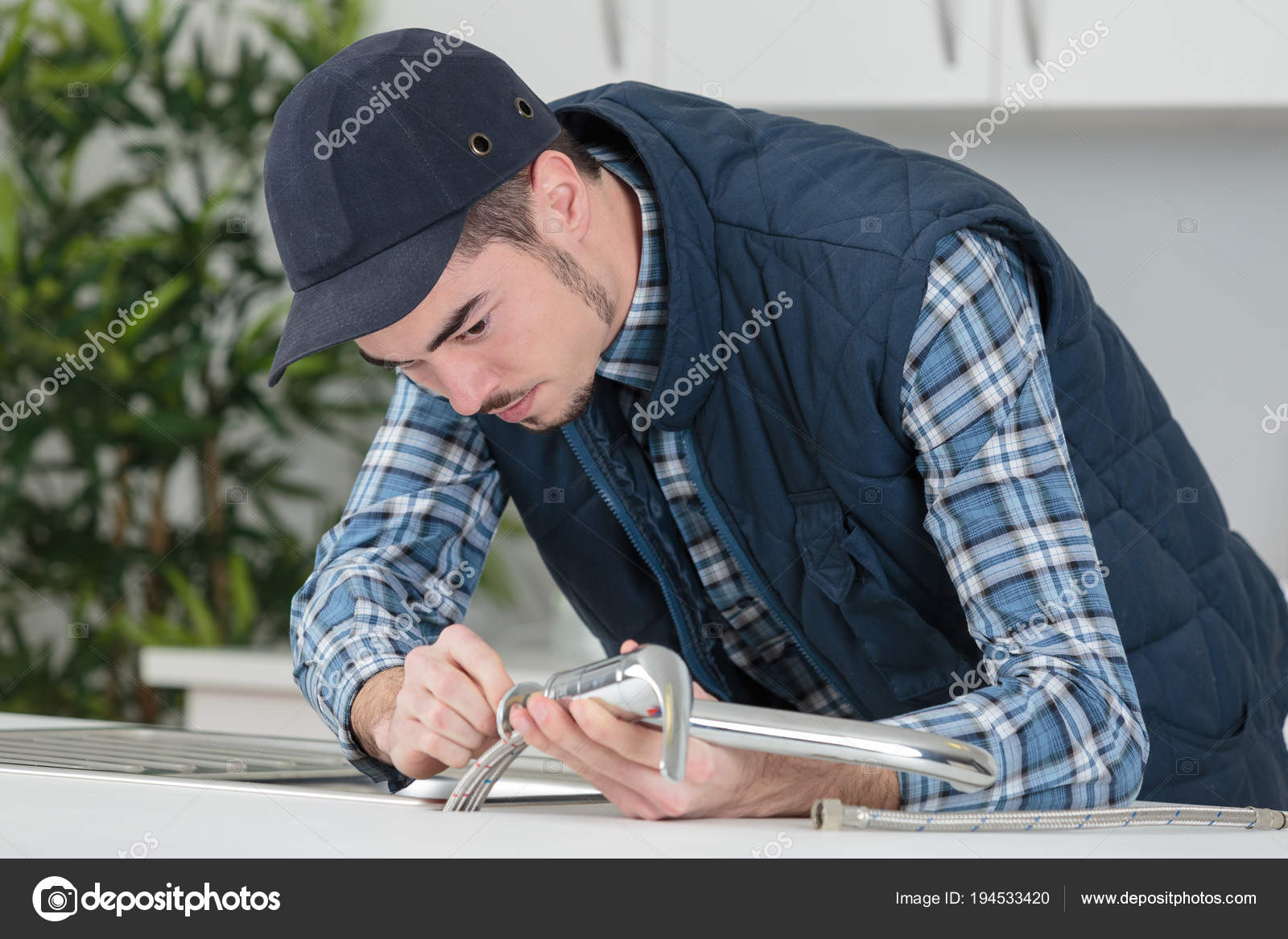 Joven artesano reparación de grifo en la cocina — Fotos de Stock