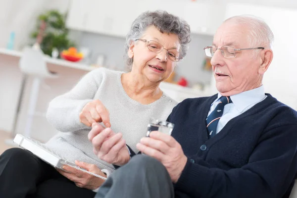 Старушка помогает мужу принимать правильные таблетки — стоковое фото