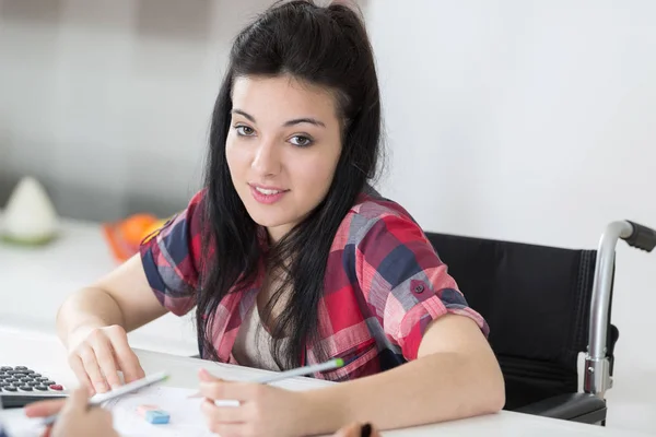 Giovane donna in sedia a rotelle che studia — Foto Stock