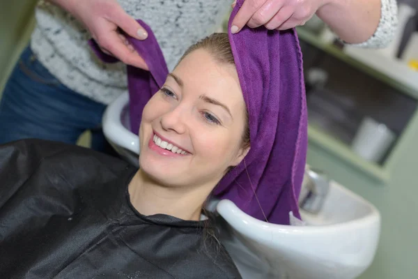 Parrucchiere avvolgendo la testa dei clienti con asciugamano — Foto Stock