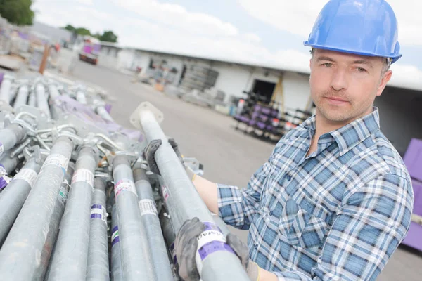 Arbetstagare som innehar byggnadsställningar pole — Stockfoto