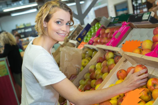 Jovem mulher comprando maçã no mercado — Fotografia de Stock