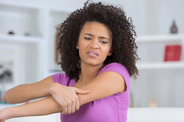 Young woman suffering from pain in elbow — Stock Photo, Image