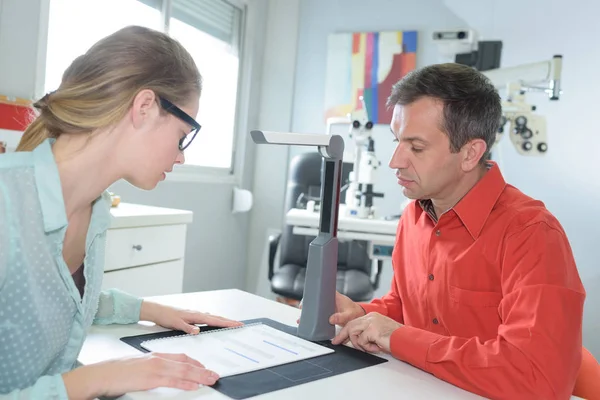 Handsome ophthalmologist working with patient in clinic — Stock Photo, Image