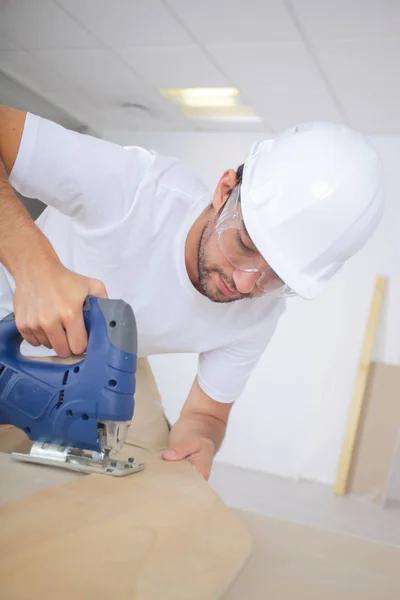 Man använder en elektrisk sticksåg — Stockfoto