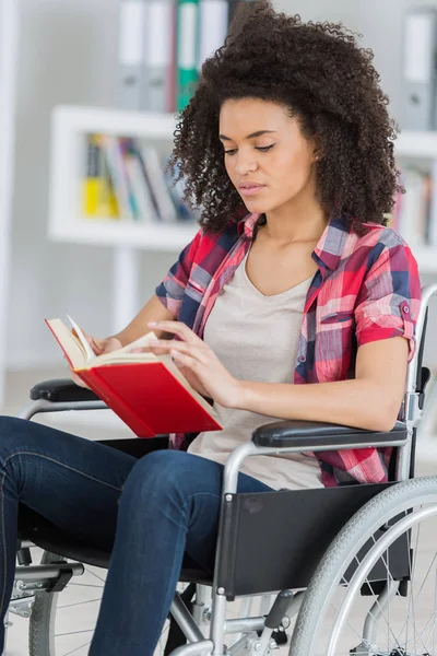 Mulher em cadeira de rodas lendo um livro — Fotografia de Stock