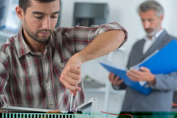 Junger männlicher Techniker repariert Klimaanlage mit Schraubenzieher — Stockfoto