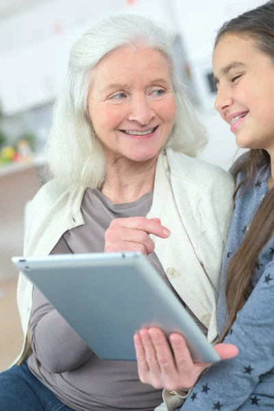 Flickan lär mormor Hur man använder en surfplatta — Stockfoto