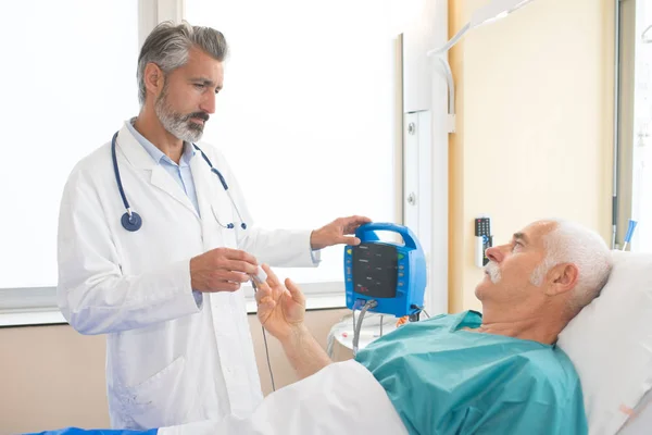 Médico tomando pulso do paciente com dispositivo eletrônico — Fotografia de Stock