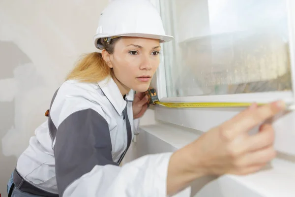 Trabalhador do sexo feminino medir a janela — Fotografia de Stock