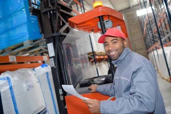 Forklift is putting cargo from warehouse to truck outdoors — Stock Photo, Image