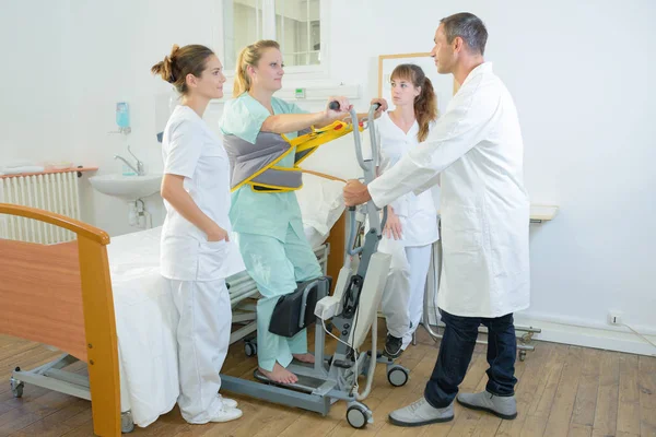 Patient debout dans une salle médicale avec des médecins — Photo