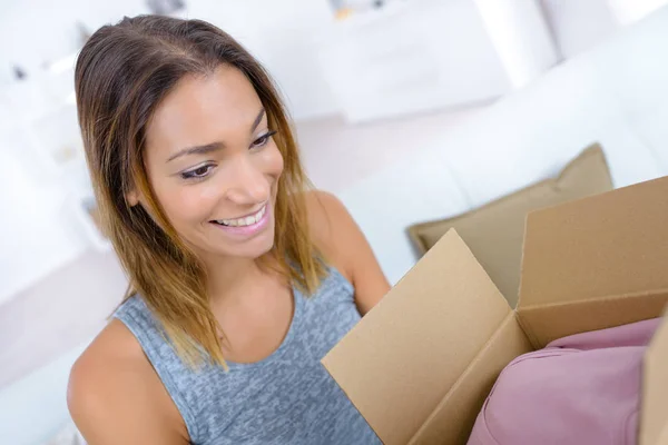 Young woman looking into open box — Stock Photo, Image