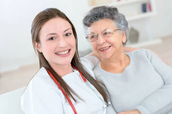 Vieille dame souriant à une infirmière — Photo