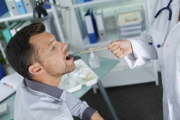 Läkaren undersöker en patient-kontoret — Stockfoto