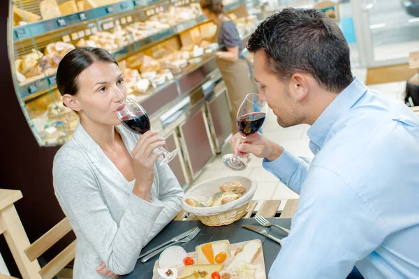 Pareja comiendo, bebiendo sus copas de vino — Foto de Stock