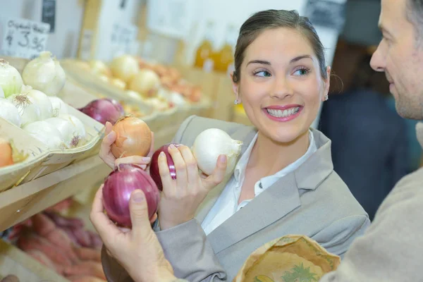 Mujer sosteniendo diferentes tipos de cebollas — Foto de Stock