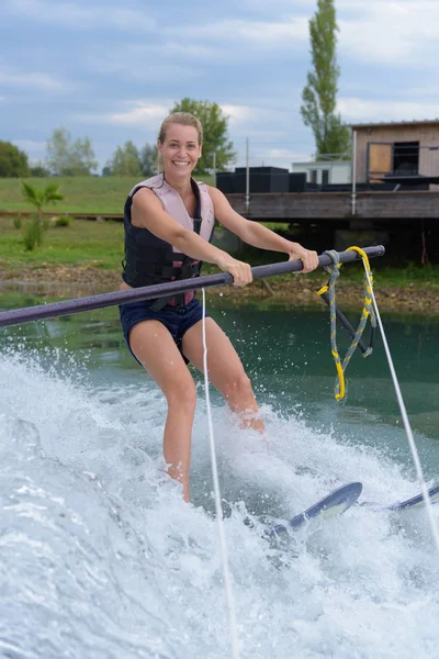 Menina aprendendo esqui aquático e feminino — Fotografia de Stock