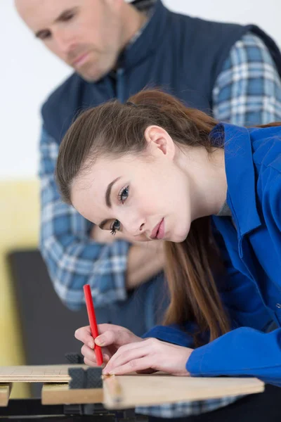 Female carpenter measuring wood — Stock Photo, Image